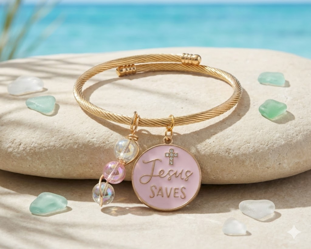 Gold bracelet with 'Jesus Saves' charm on a beach setting