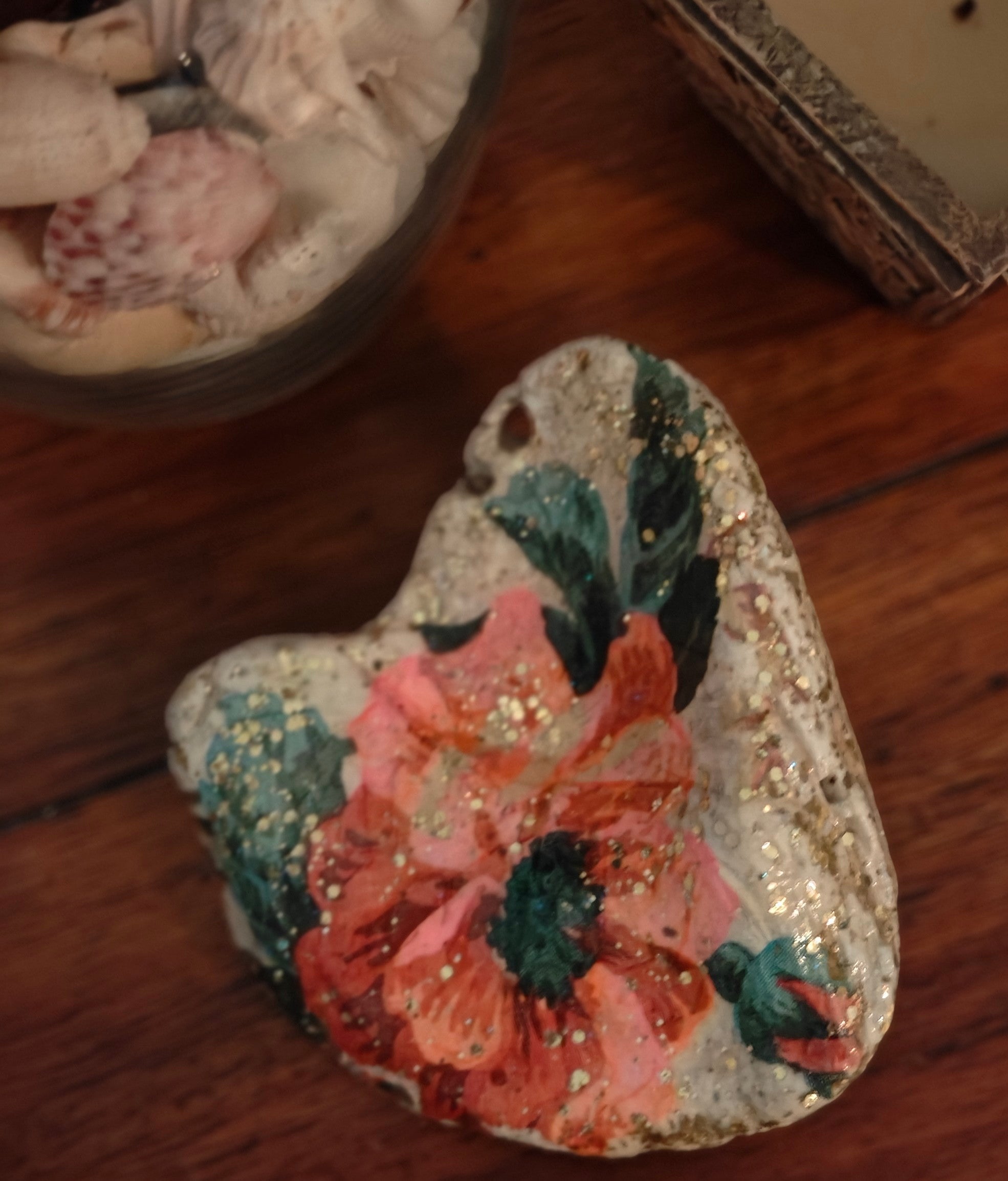 “Hand‑decorated off‑white natural shell featuring a beautiful pink flower design.